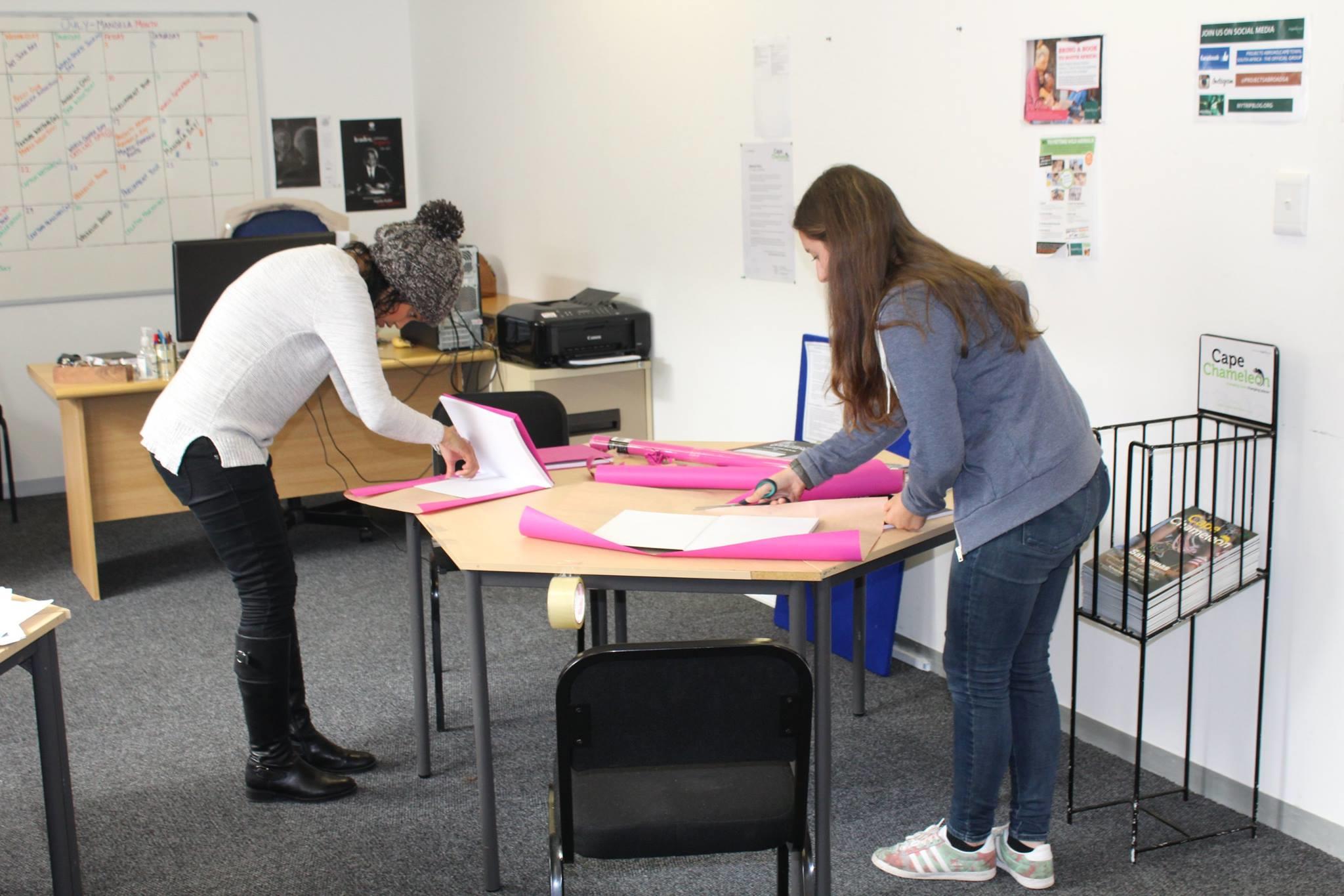 Two Journalism interns prepare materials for a workshop in Cape Town, South Africa. Students doing Journalism internships in South Africa create materials for a creative workshop.
